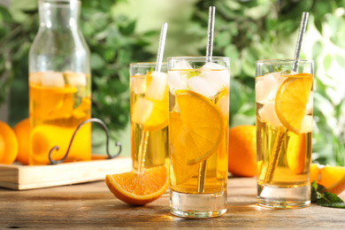 Photo of Delicious refreshing drink with orange slices on wooden table