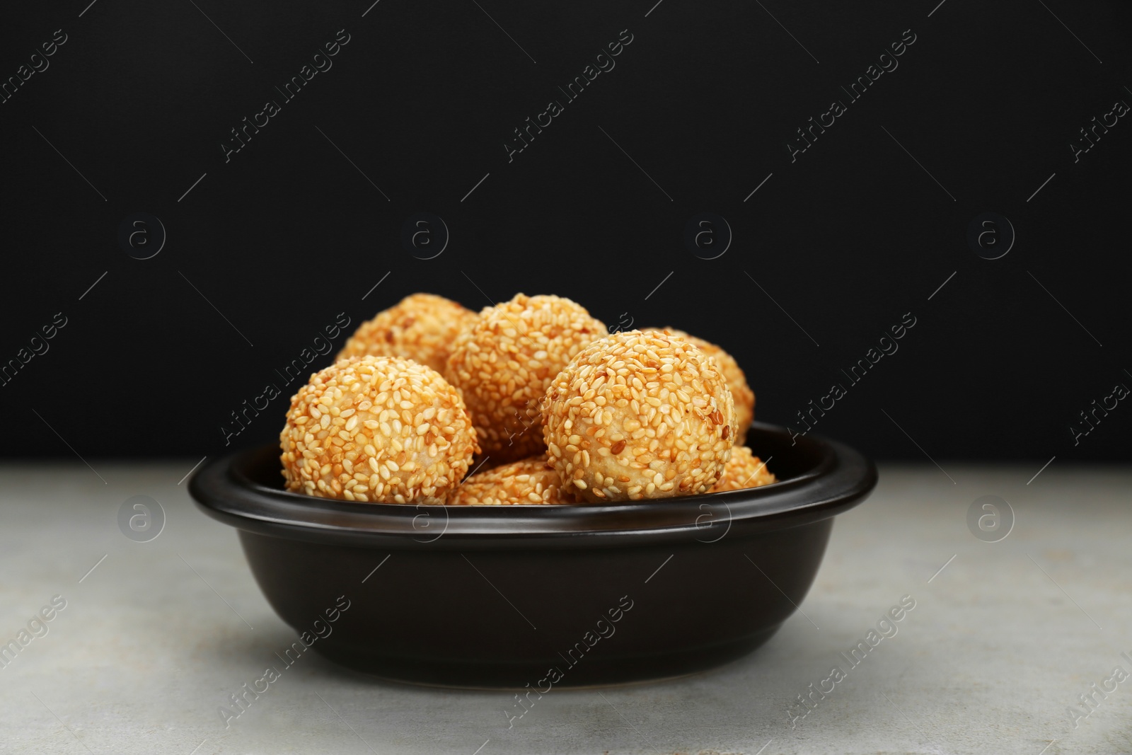 Photo of Many delicious sesame balls on textured table
