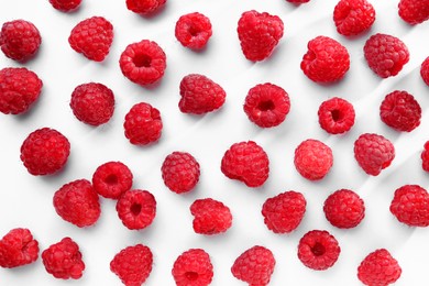 Photo of Tasty ripe raspberries on white background, flat lay