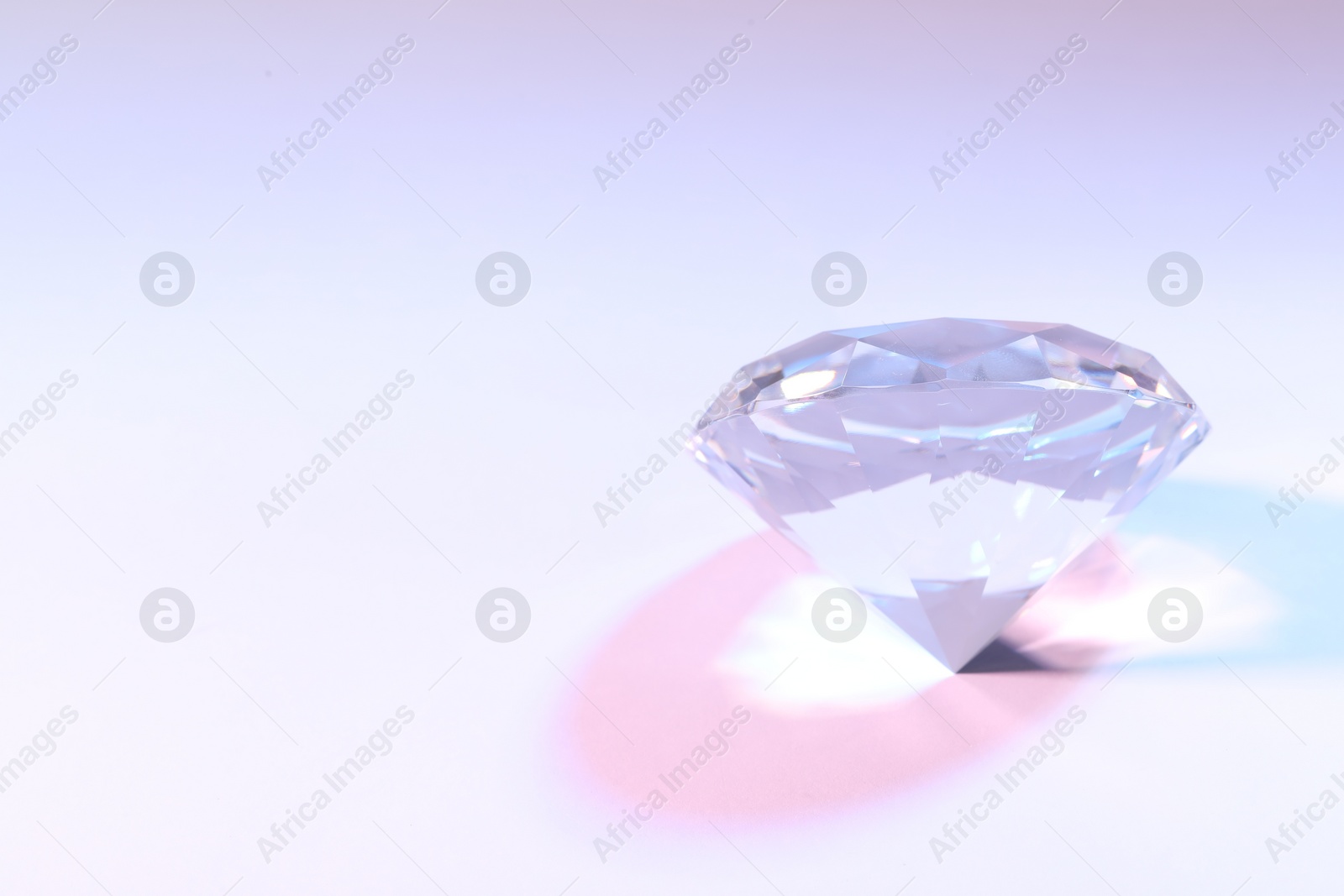 Photo of Beautiful dazzling diamond on color background. Space for text