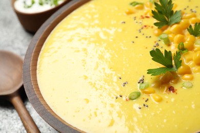 Photo of Delicious creamy corn soup in wooden bowl, closeup