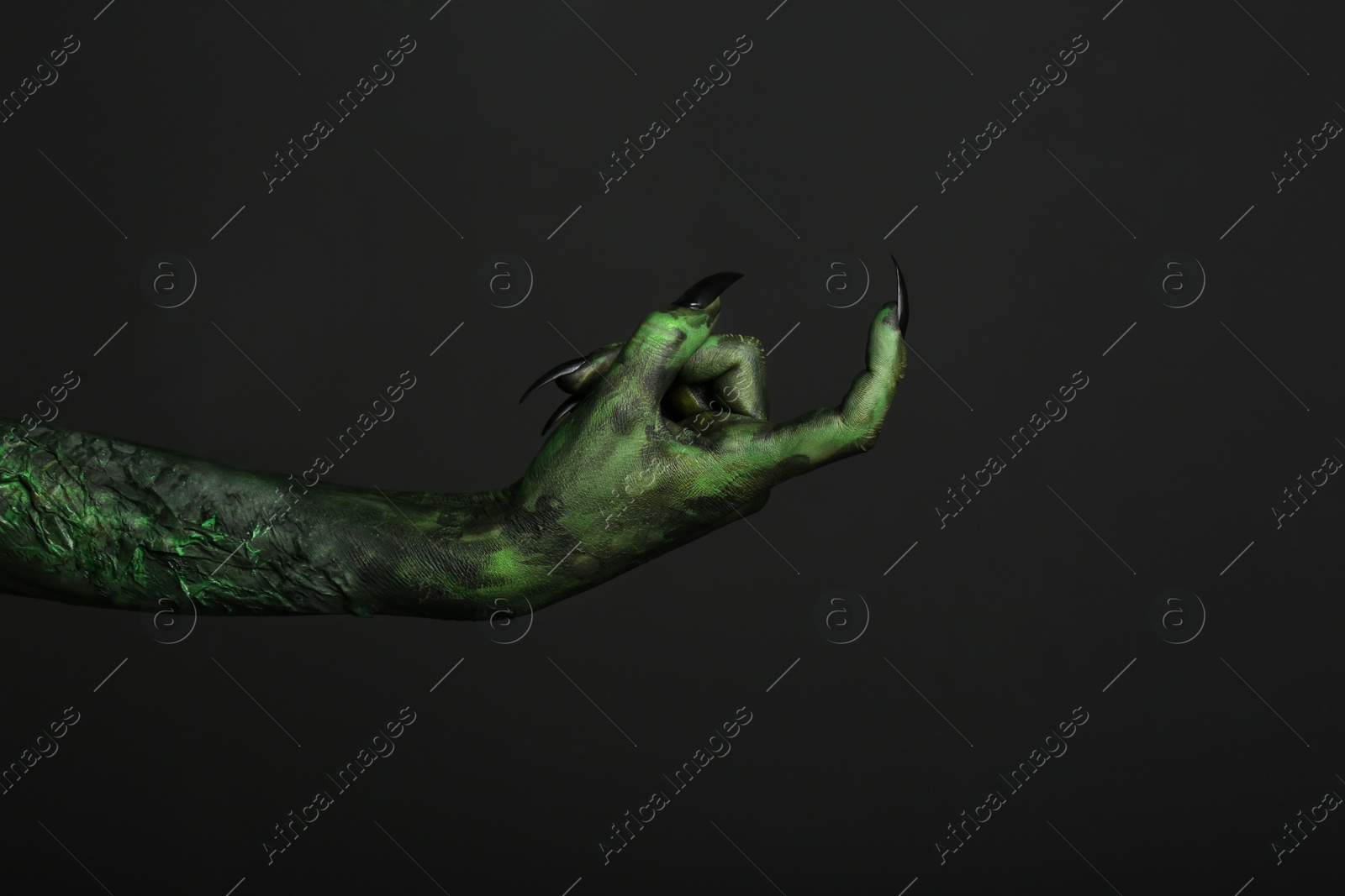 Photo of Scary monster on black background, closeup of hand. Halloween character