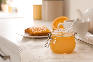 Photo of Breakfast with delicious orange marmalade on table. Space for text