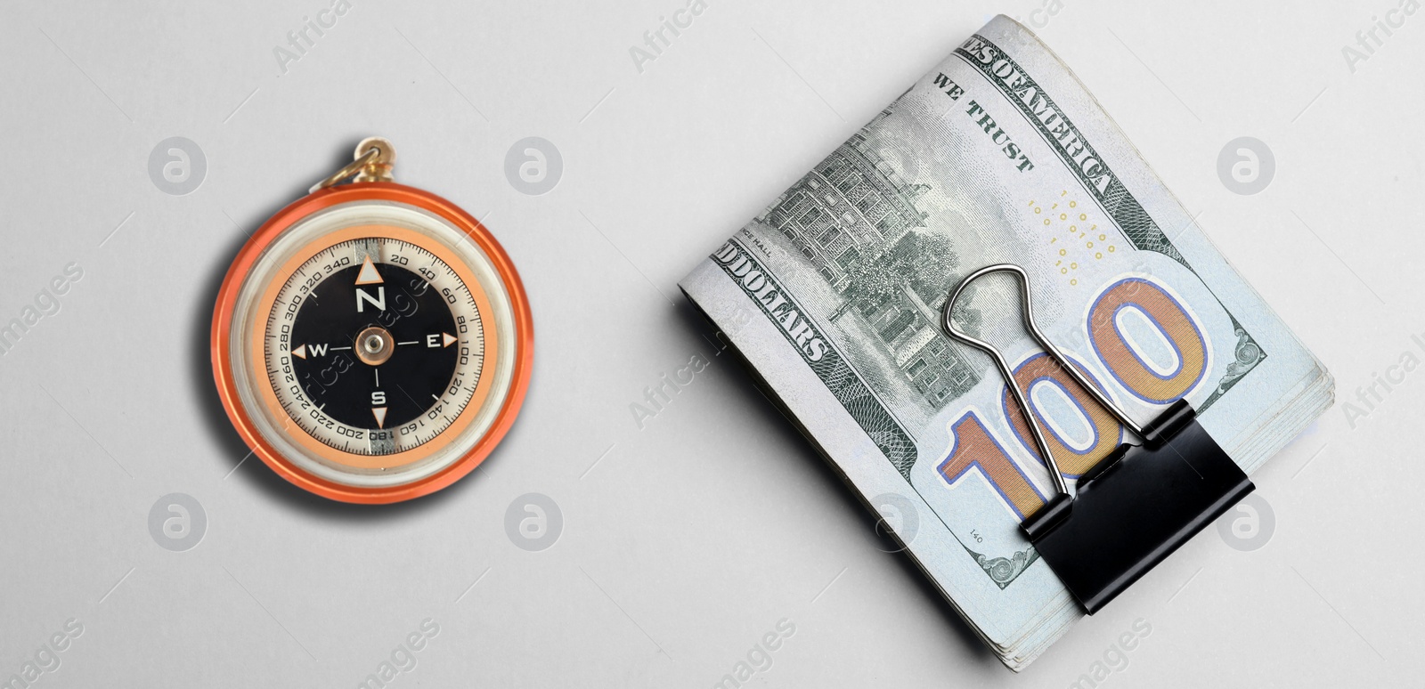 Image of Exchange rate. Money (dollar banknotes) and compass on white background, flat lay. Banner design
