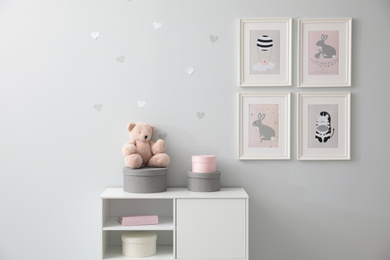 Photo of Stylish baby room interior with chest of drawers and cute pictures on wall