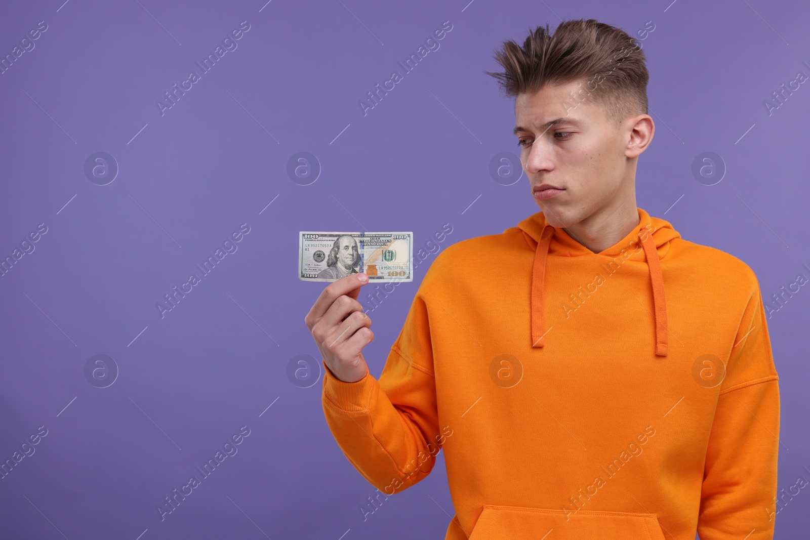 Photo of Upset man with dollar banknote on purple background. Space for text