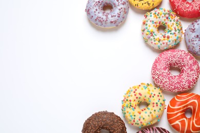 Photo of Delicious glazed donuts on white background, flat lay. Space for text