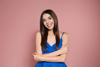 Photo of Portrait of beautiful smiling woman in stylish clothes on pink background