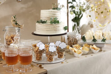 Photo of Beautiful cake and other treats on table in room. Baby shower party