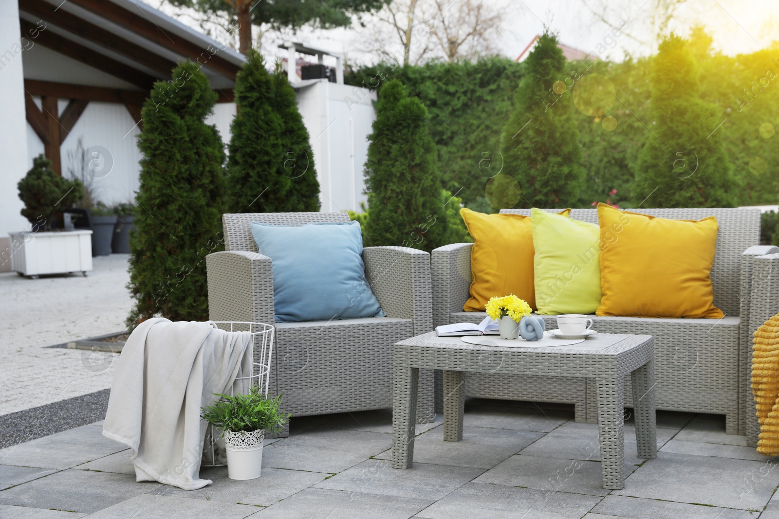 Photo of Beautiful rattan garden furniture, soft pillows and different decor elements in backyard