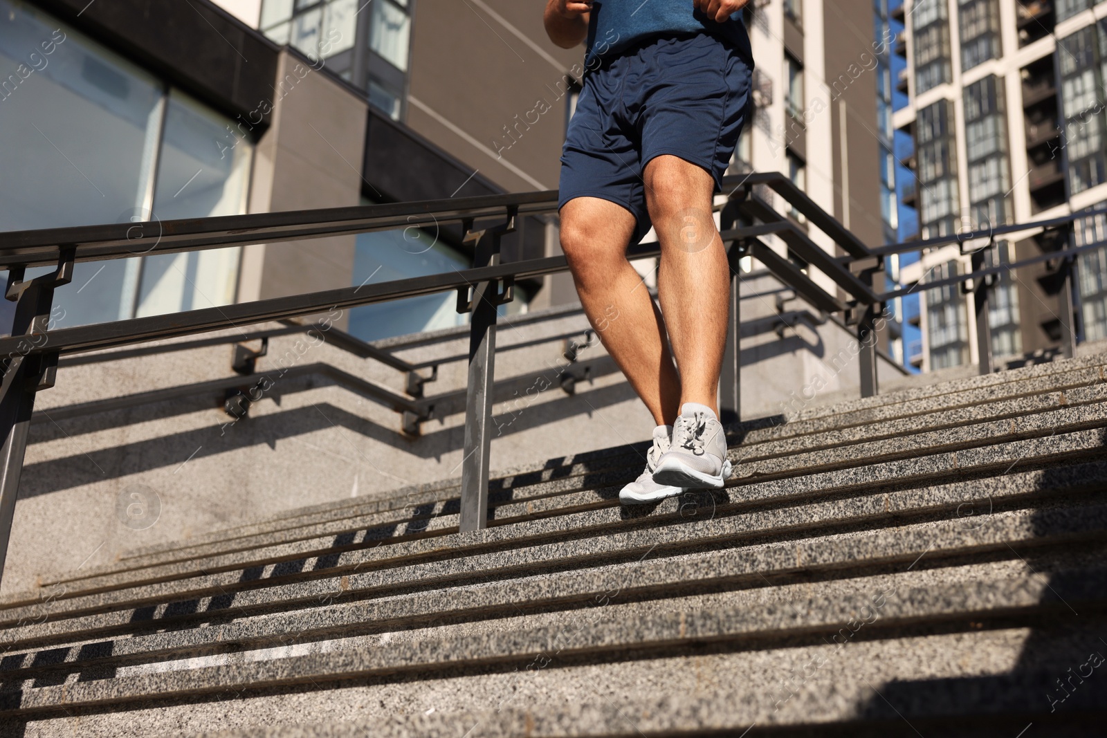 Photo of Man running down stairs outdoors on sunny day, closeup. Space for text