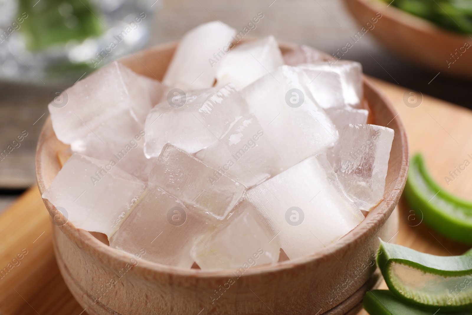 Photo of Aloe vera gel and slices of plant on table, closeup