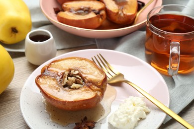 Delicious quince baked with honey and walnuts on wooden table