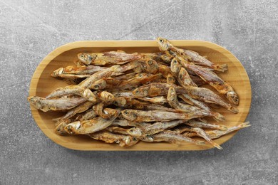 Photo of Delicious dried anchovies on grey table, top view