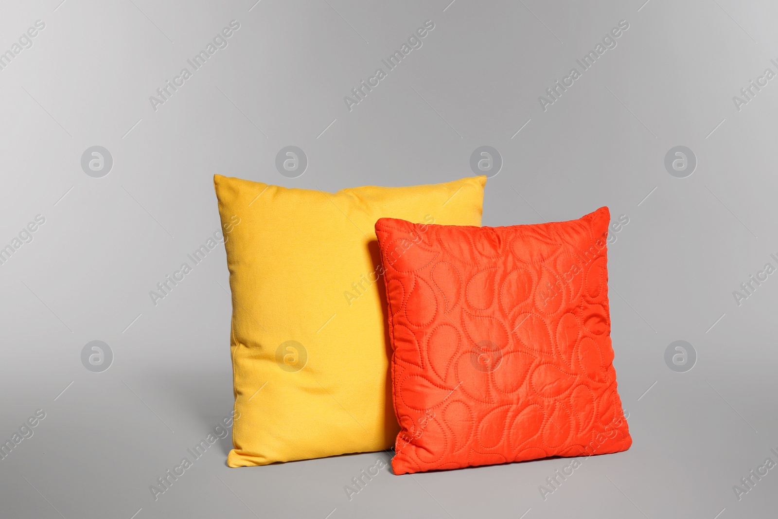 Photo of Two stylish decorative pillows on light background