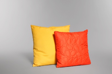 Photo of Two stylish decorative pillows on light background