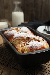 Delicious yeast dough cake in baking pan on wooden table, closeup
