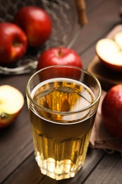 Photo of Glass of delicious apple cider on wooden table. Space for text