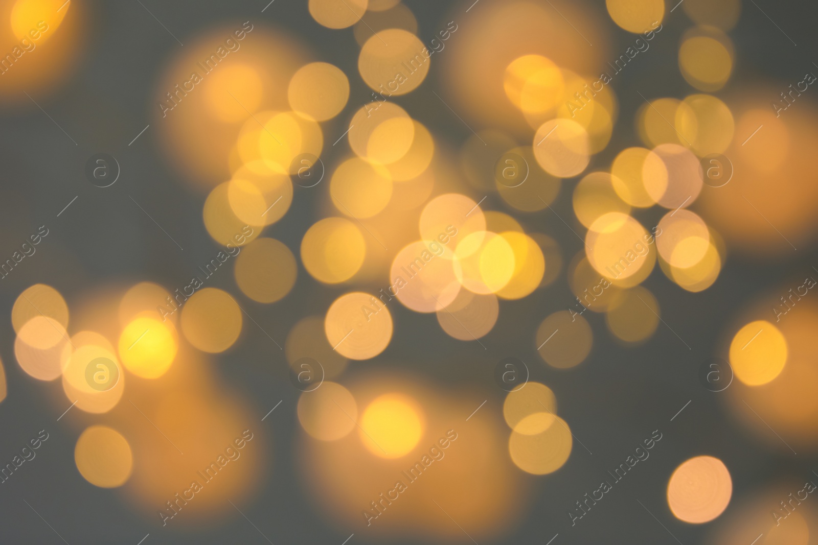 Photo of Blurred view of gold lights on dark background. Bokeh effect