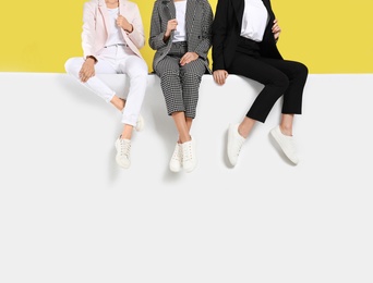 Photo of Women wearing stylish shoes on color background, closeup