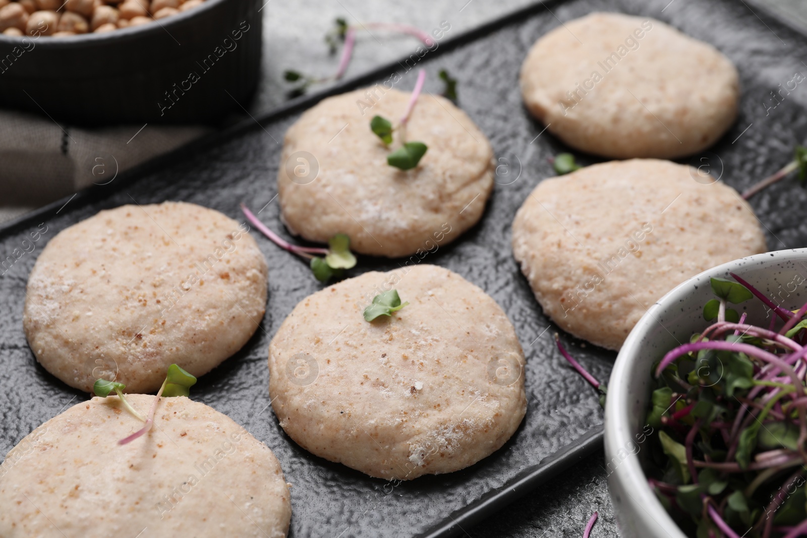 Photo of Raw vegan nuggets and spices on slate plate, closeup