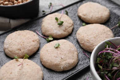 Raw vegan nuggets and spices on slate plate, closeup