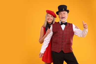 Photo of Portrait of senior couple on orange background, space for text