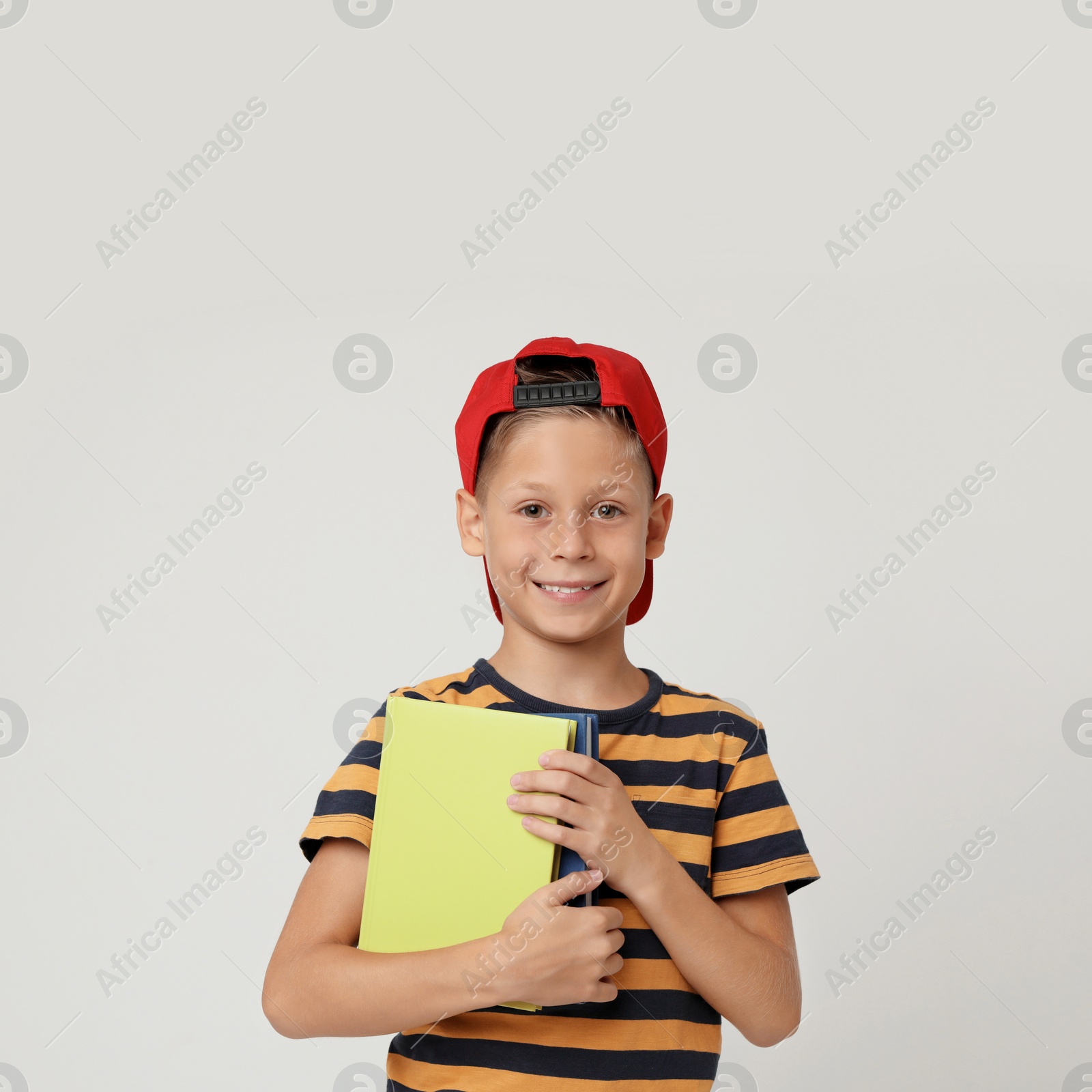 Photo of Portrait of cute little boy with books on grey background. Reading concept