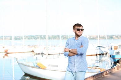 Photo of Young hipster man in jeans on pier