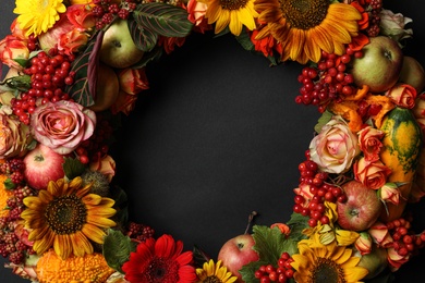 Photo of Beautiful autumnal wreath with flowers, berries and fruits on black background, closeup. Space for text