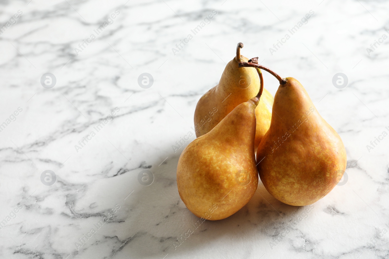 Photo of Ripe pears on marble background. Space for text