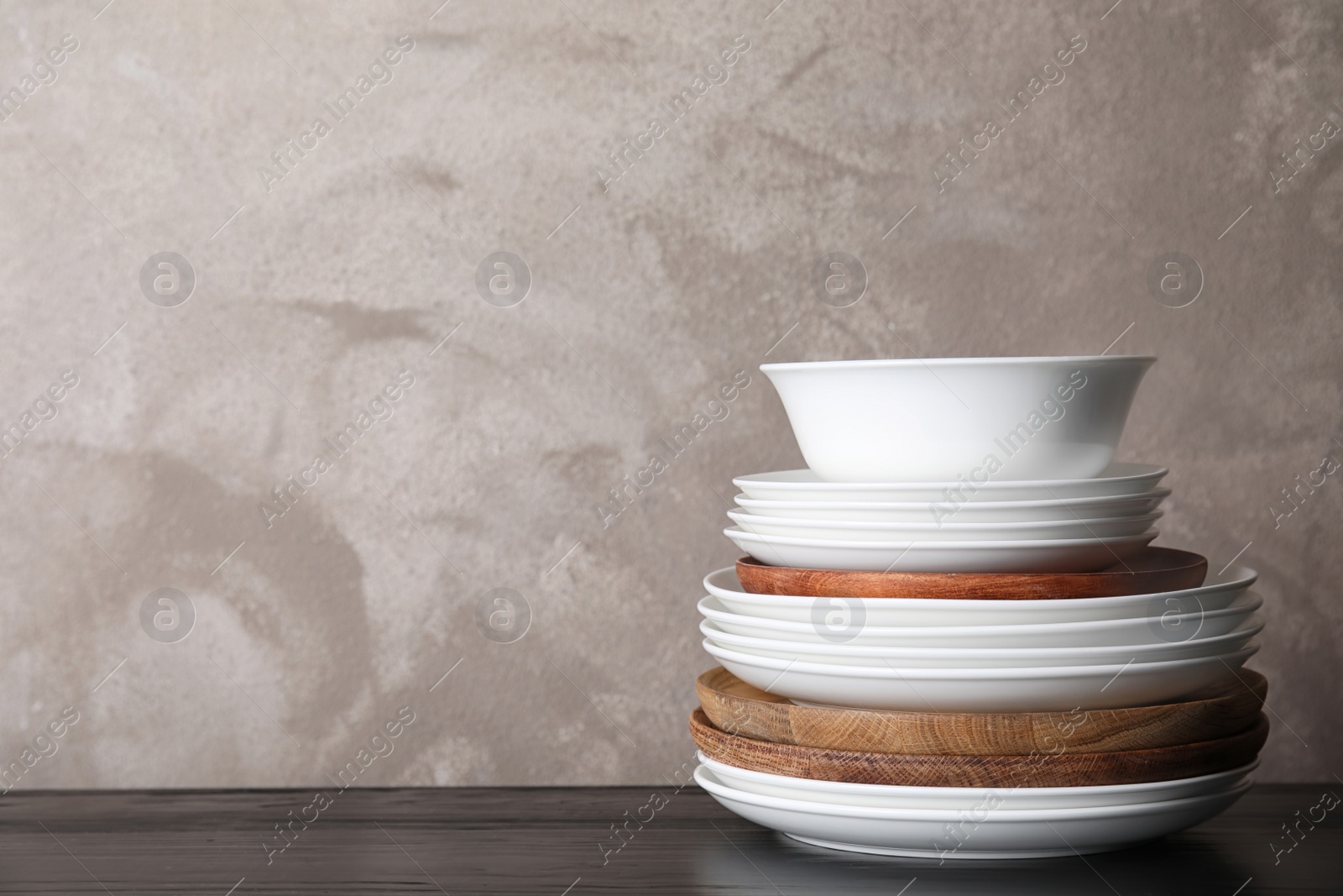 Photo of Set of dinnerware on table against grey background with space for text. Interior element