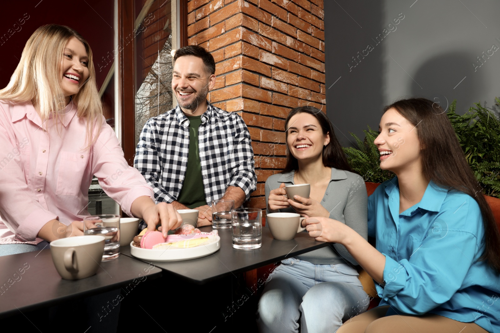 Photo of Friends with coffee spending time together in cafe