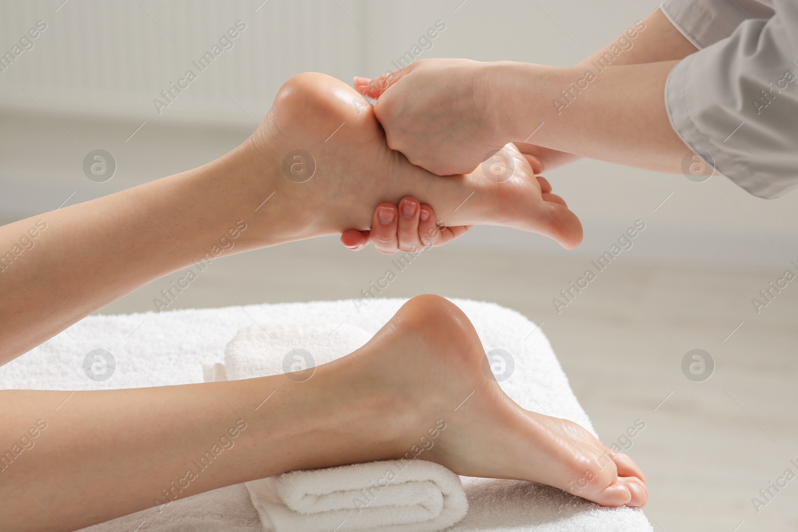 Photo of Woman receiving foot massage in spa salon, closeup