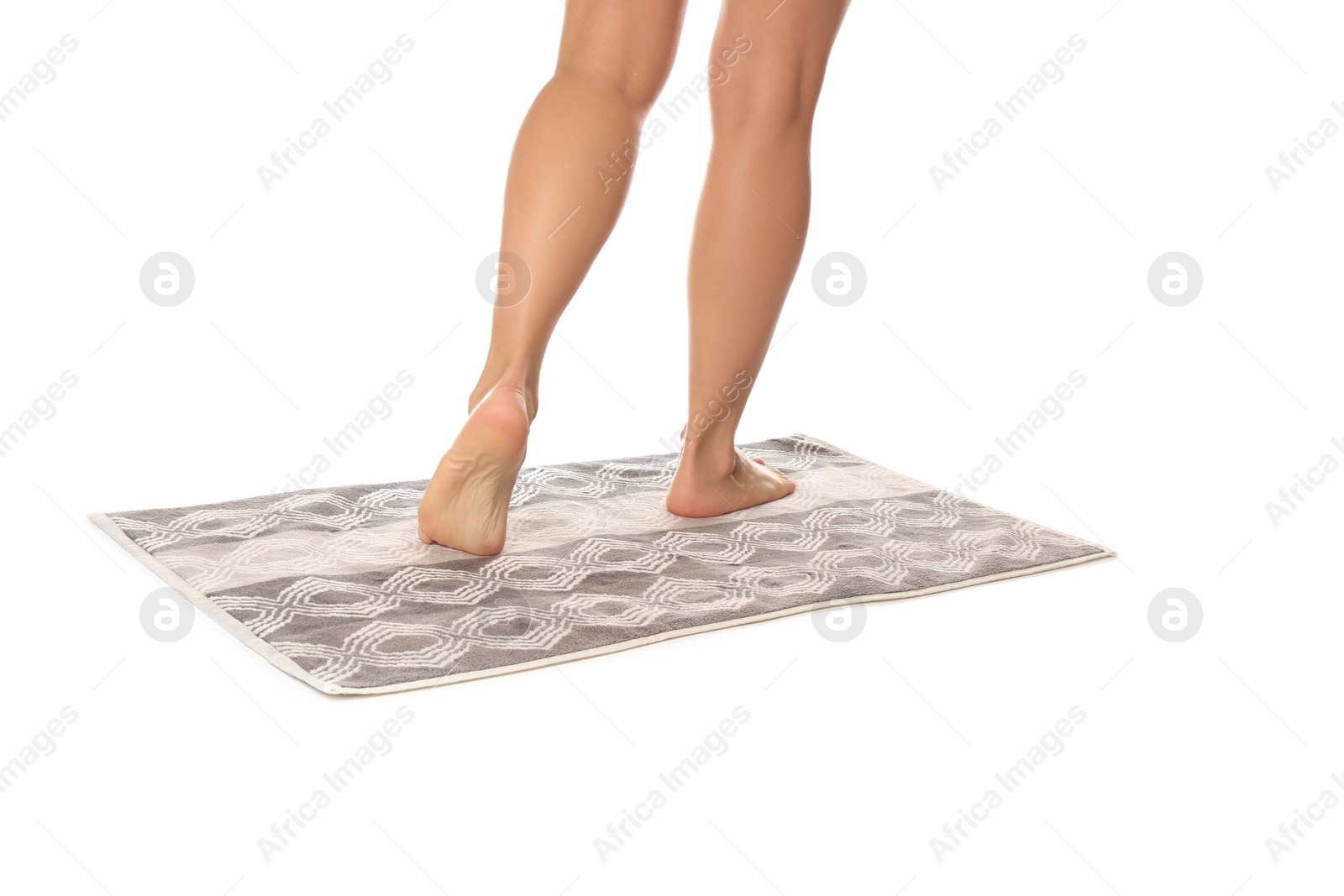 Photo of Woman standing on stylish bath mat against white background, closeup