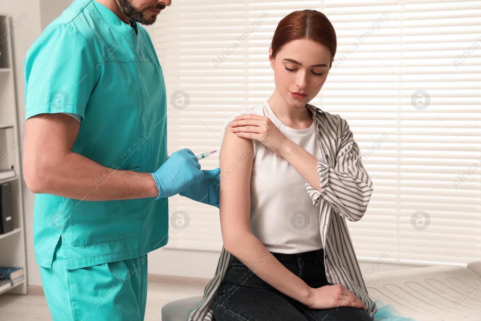 Photo of Doctor giving hepatitis vaccine to patient in clinic