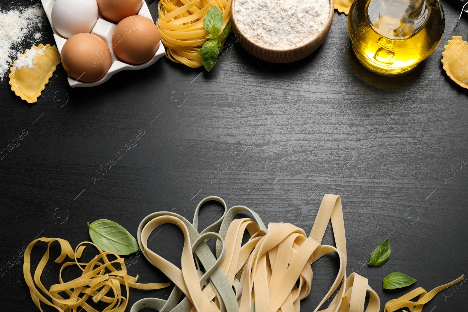 Photo of Flat lay composition with different types of pasta on black wooden table. Space for text
