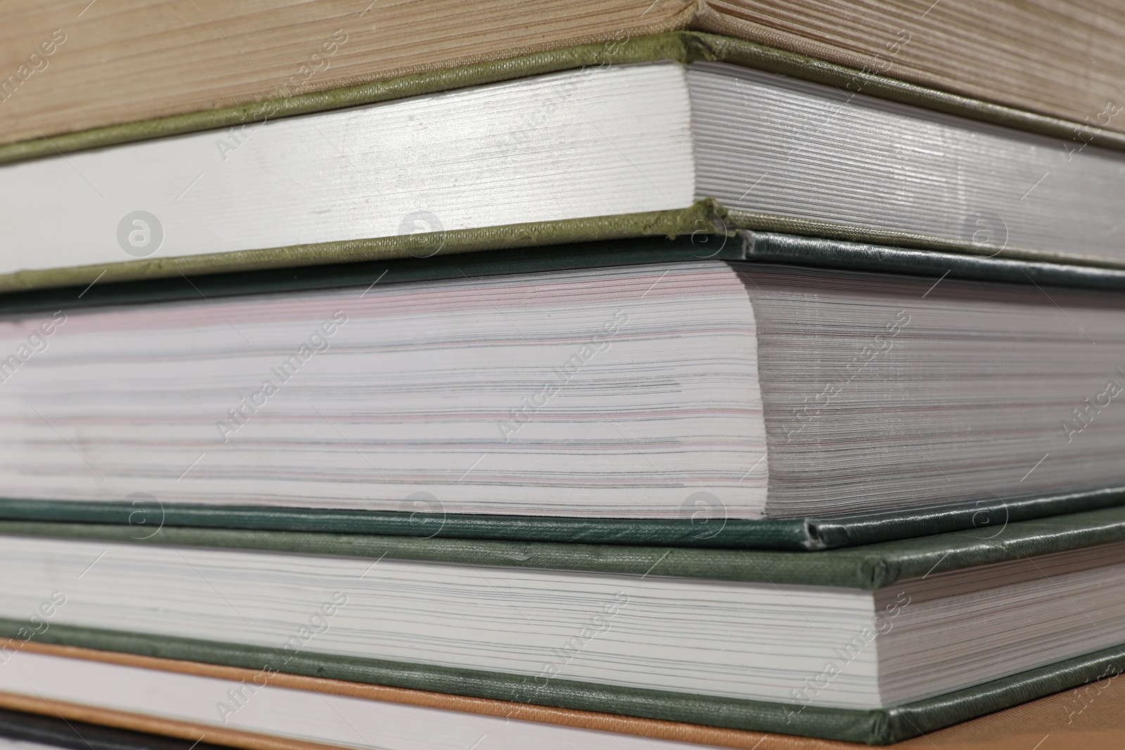 Photo of Stack of many different hardcover books as background, closeup