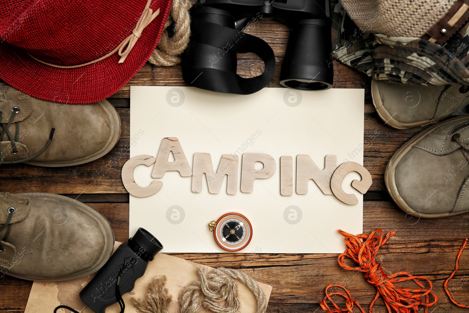 Photo of Flat lay composition with camping equipment on wooden background