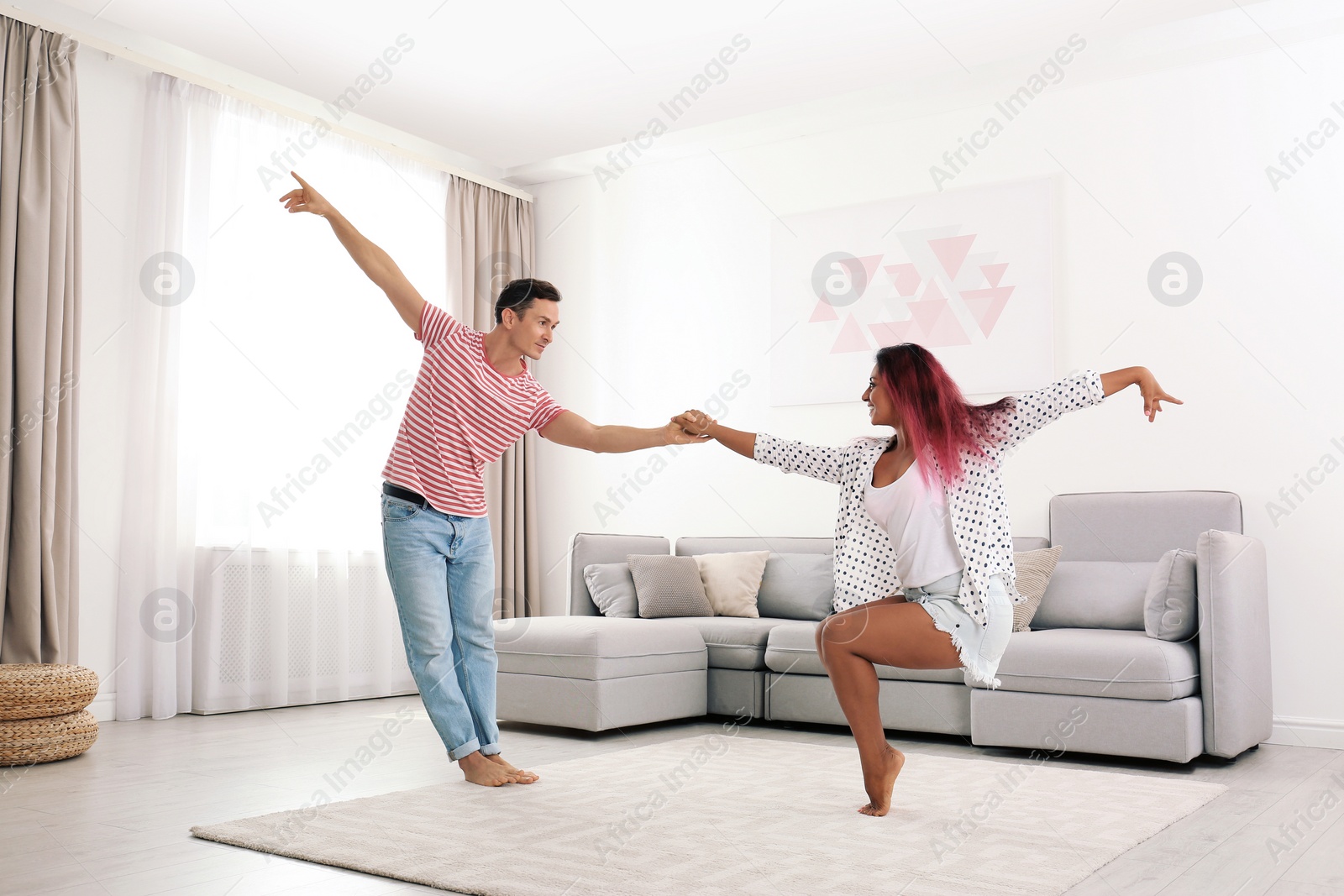 Photo of Beautiful happy couple dancing in living room at home