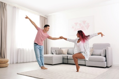 Photo of Beautiful happy couple dancing in living room at home
