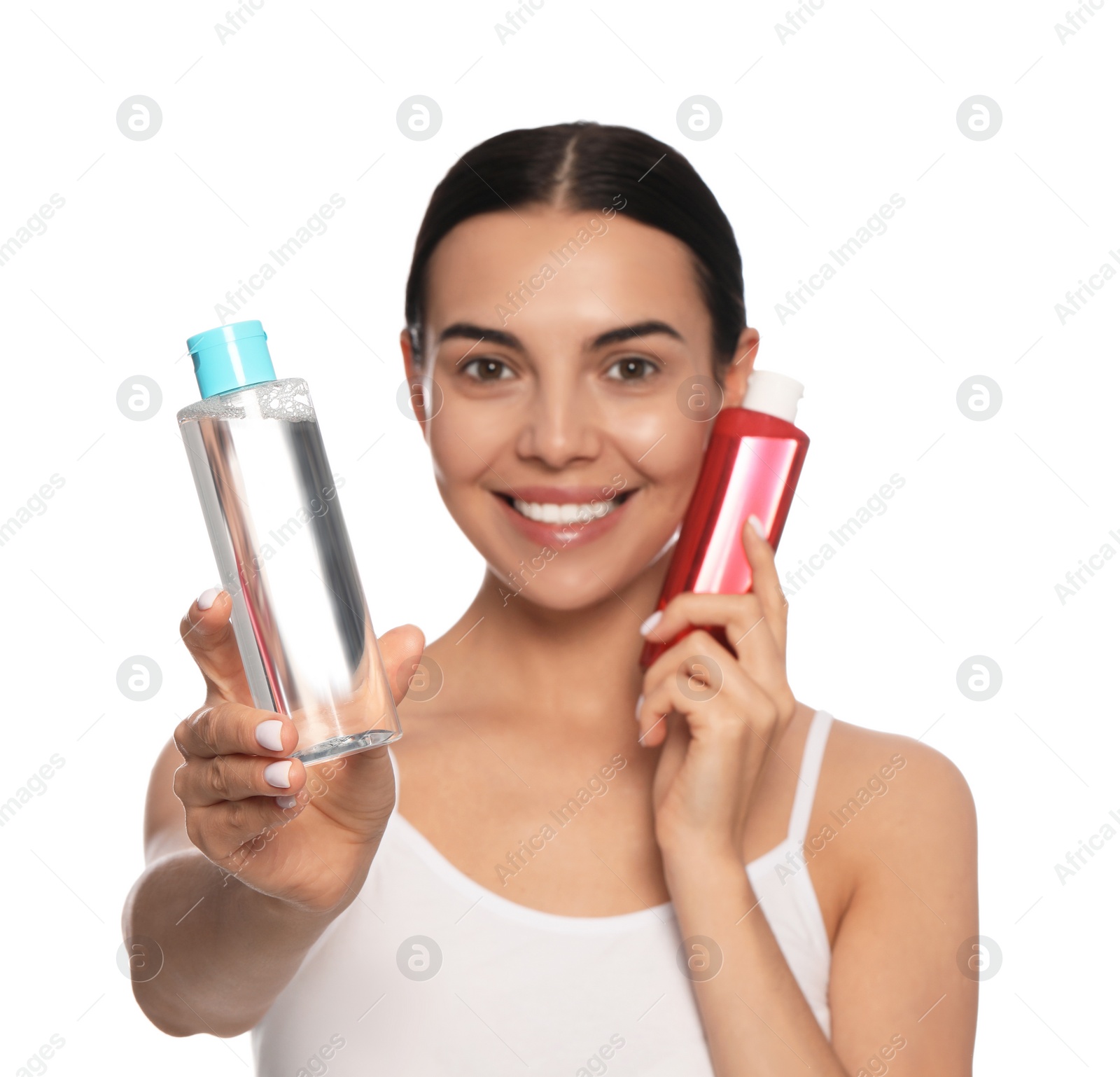 Photo of Young woman with bottles of micellar water on white background