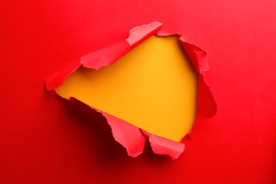 Photo of Hole in red paper on yellow background