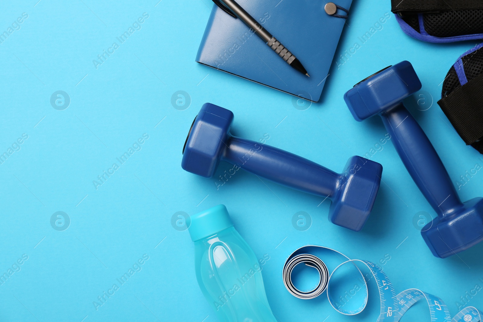 Photo of Flat lay composition with dumbbells on light blue background, space for text