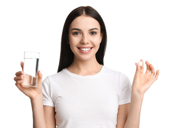 Photo of Young woman with glass of water and vitamin pill on white background