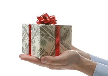Photo of Man holding gift box wrapped in decorative paper with dollar pattern on white background, closeup