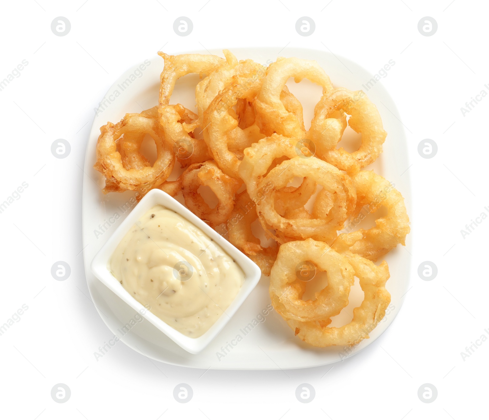 Photo of Plate with delicious crispy onion rings and sauce on white background, top view