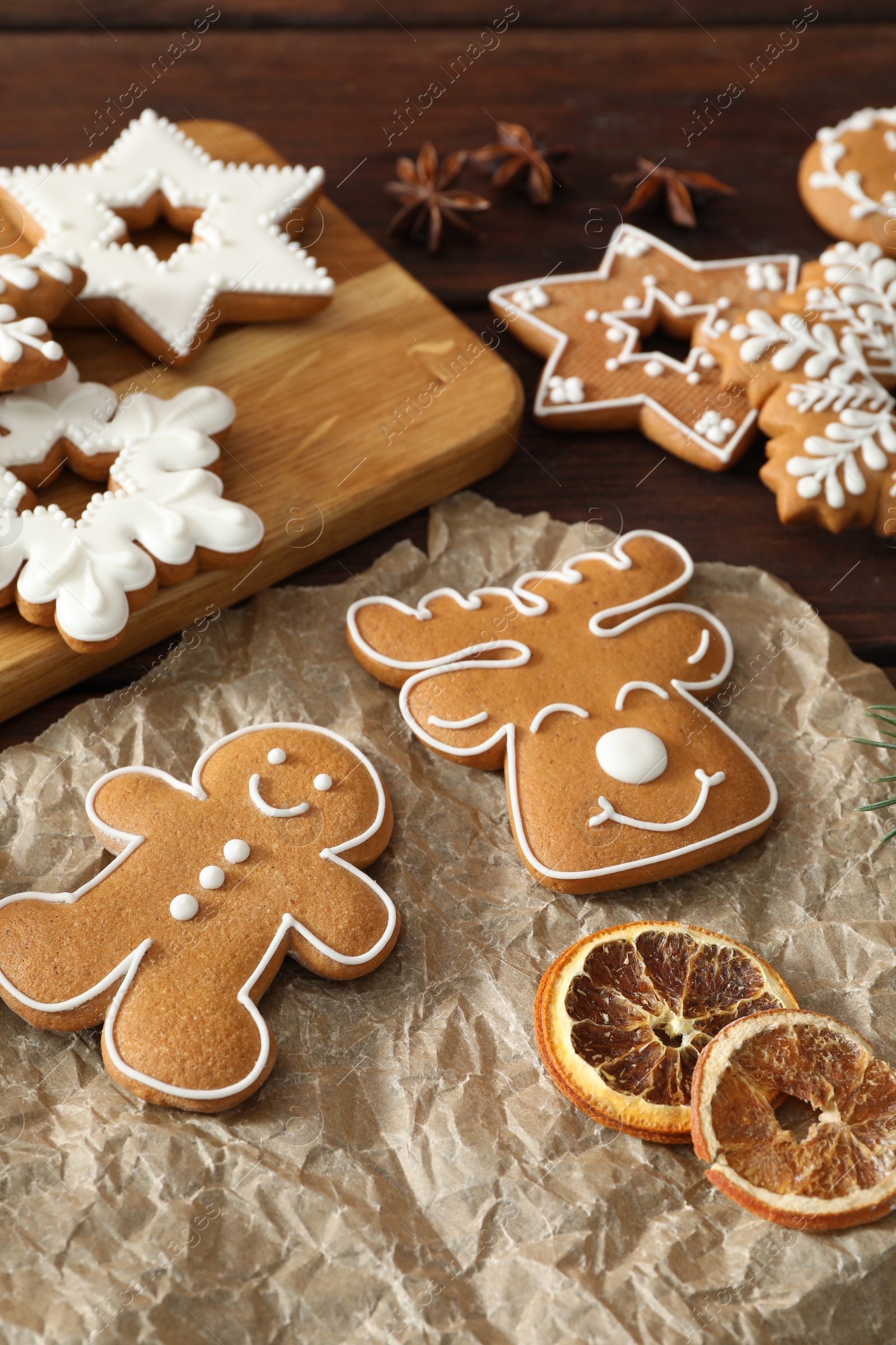 Photo of Delicious homemade Christmas cookies and dry orange on wooden table