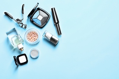 Decorative cosmetics and tools of professional makeup artist on color background