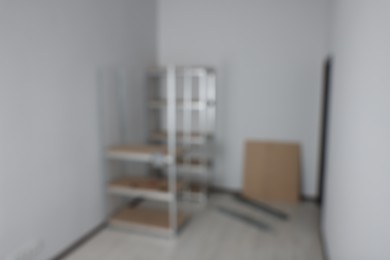 Blurred view of room with white walls and metal storage shelves